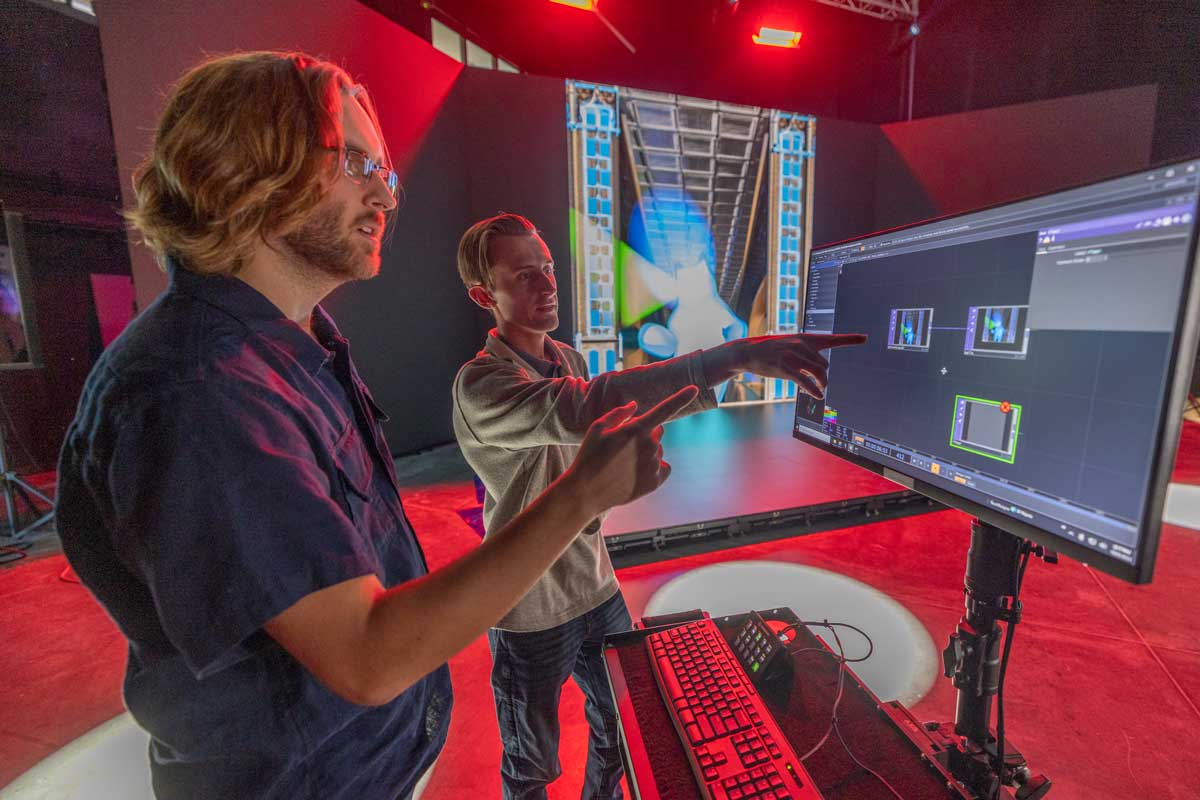 two students reviewing frames of video on a monitor.