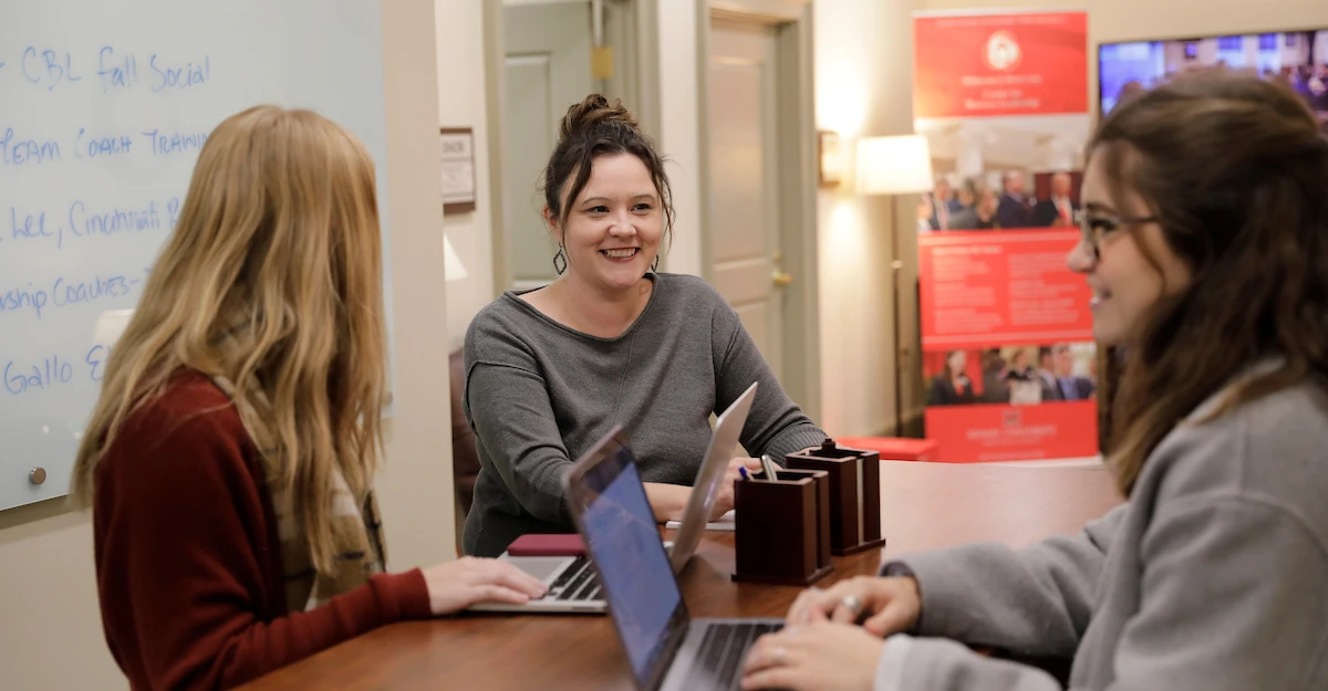 megan gerhardt with students standing at a desk
