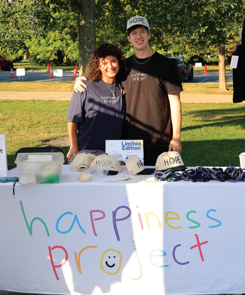 Mike Jones at a booth selling Happiness Project merch.