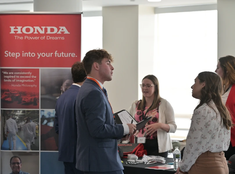 students talking at career fair with representatives from Honda