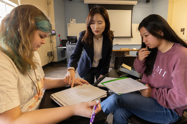 Professor working with two students in a Computational Linguistics Class