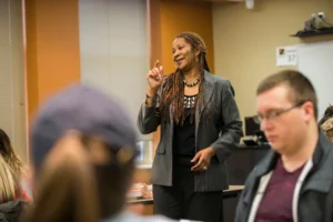 Paula Saine teaching in classroom with students looking on