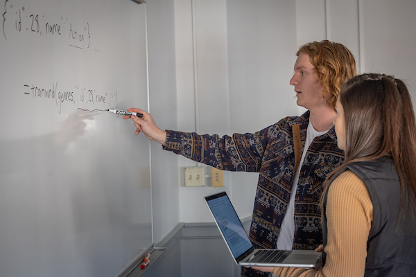 Student Data Sciencel student doing a problem at a chalkboard