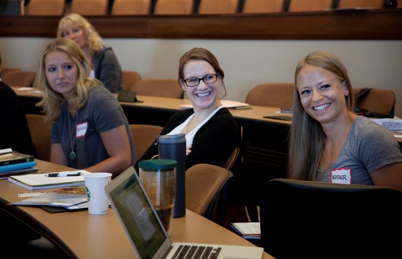 group of students at desks smiling having a conversation