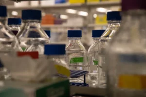 chemical lab glass bottles with purple lids and green labels
