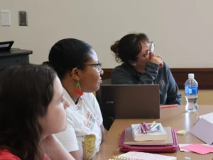 group of students sitting at table looking at presenter
