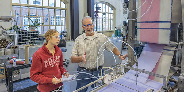 faculty member and student working on papaer