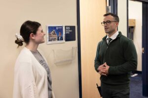 principal of local school working with miami university student in classroom