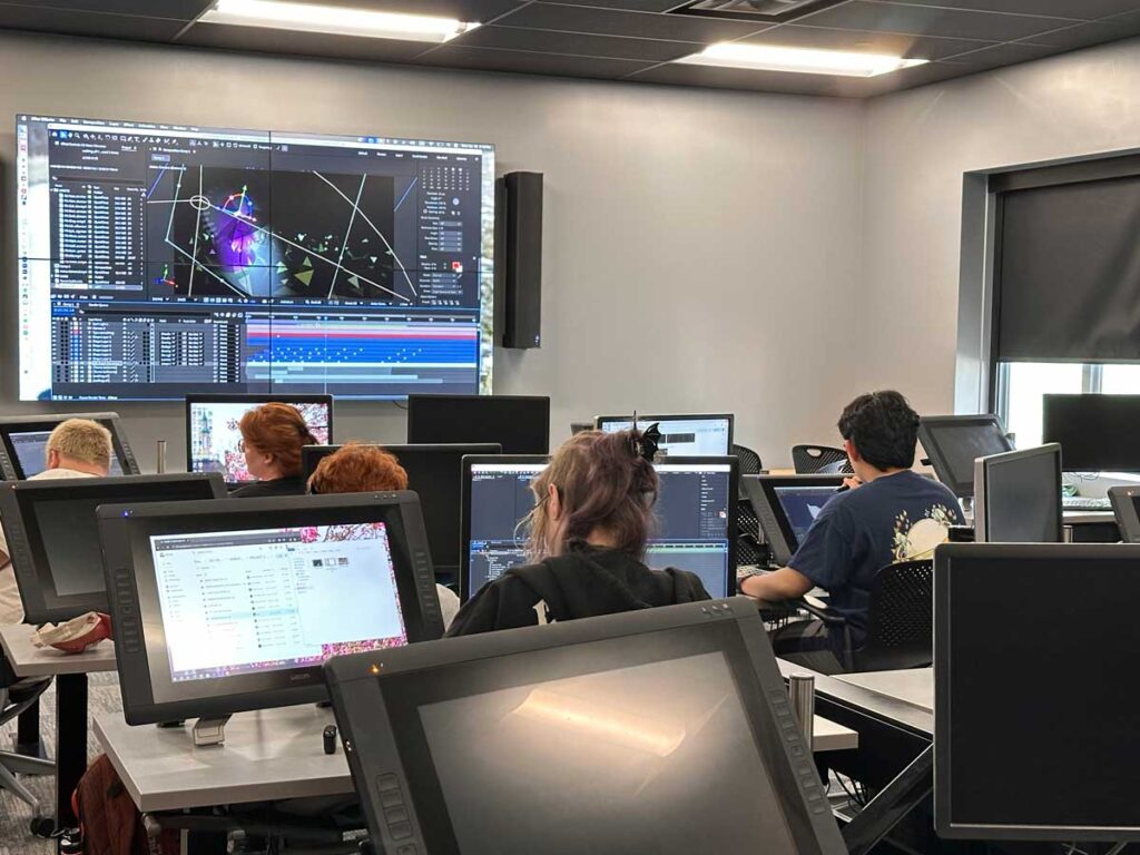 Miami University animation students work on digital projects using stylus monitors and 3D software in a high-tech lab.